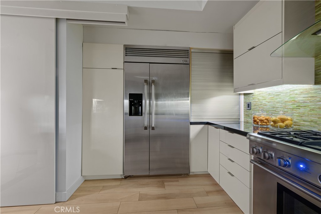 4557 Haskell Avenue, Unit 301 Encino, CA 91436 - Photo 12 of 40 a kitchen with stainless steel appliances granite countertop a refrigerator and a stove