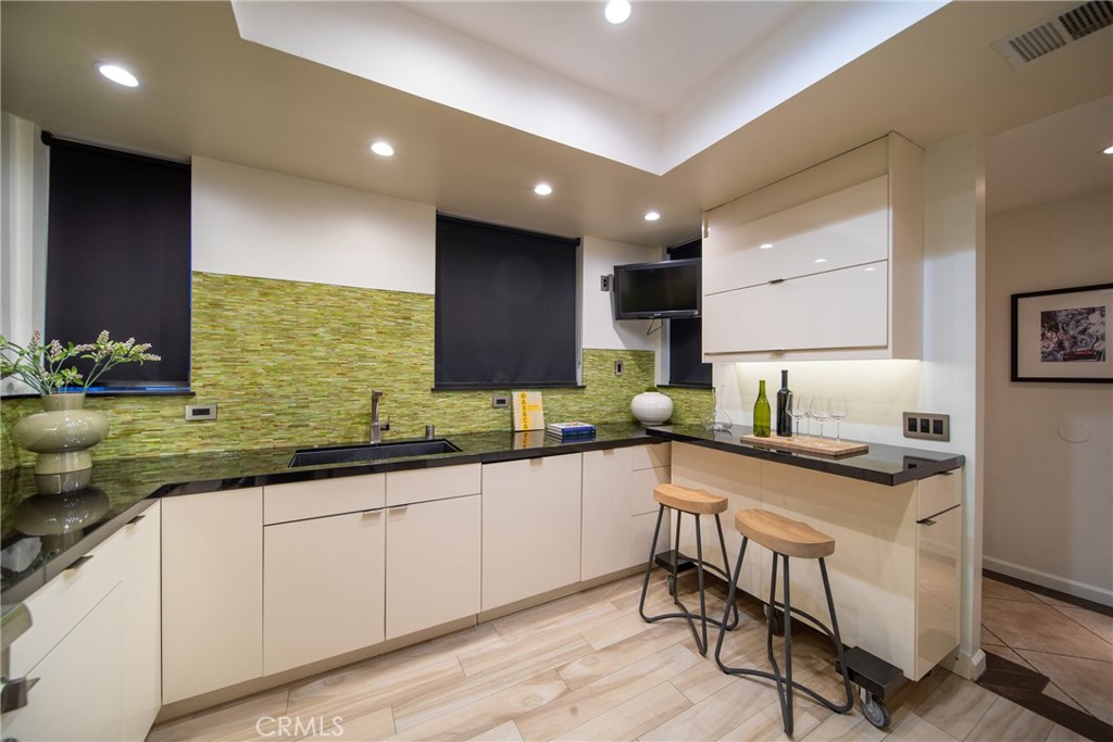 4557 Haskell Avenue, Unit 301 Encino, CA 91436 - Photo 15 of 40 a kitchen with granite countertop cabinets a sink and a stove