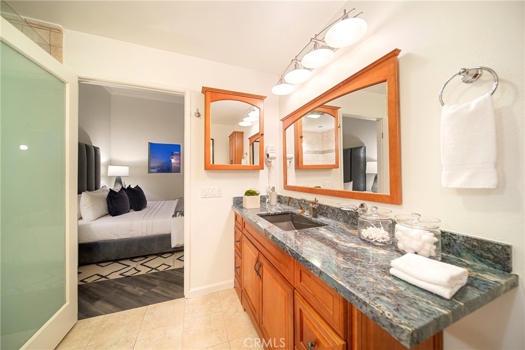 4557 Haskell Avenue, Unit 301 Encino, CA 91436 - Photo 25 of 40 a en suite bathroom with a granite countertop sink and a mirror