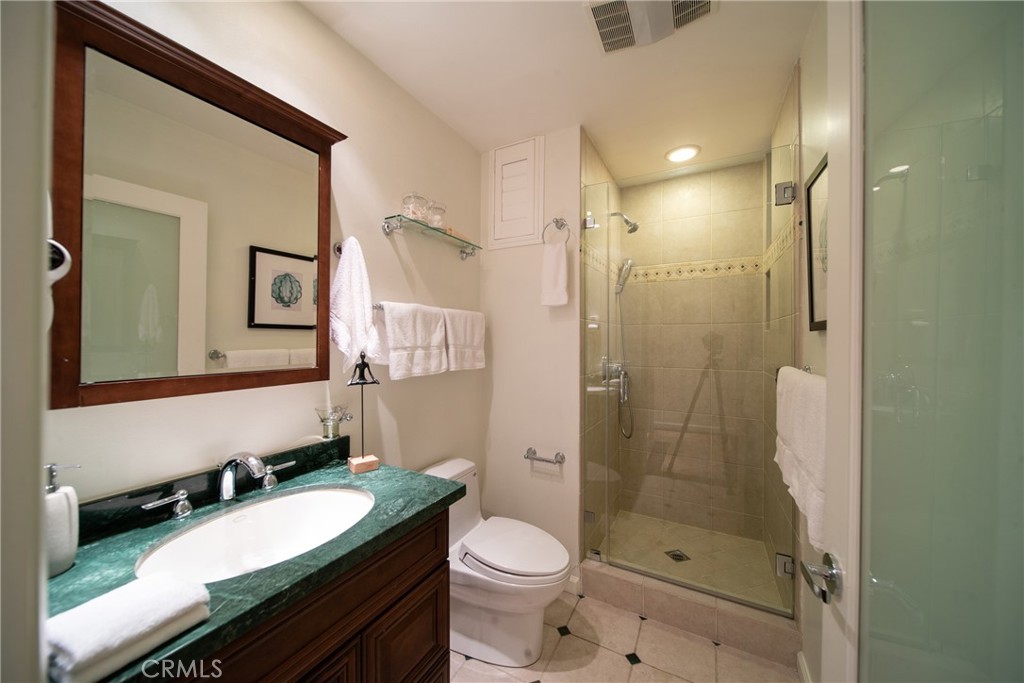4557 Haskell Avenue, Unit 301 Encino, CA 91436 - Photo 27 of 40 a bathroom with a granite countertop toilet sink shower and mirror