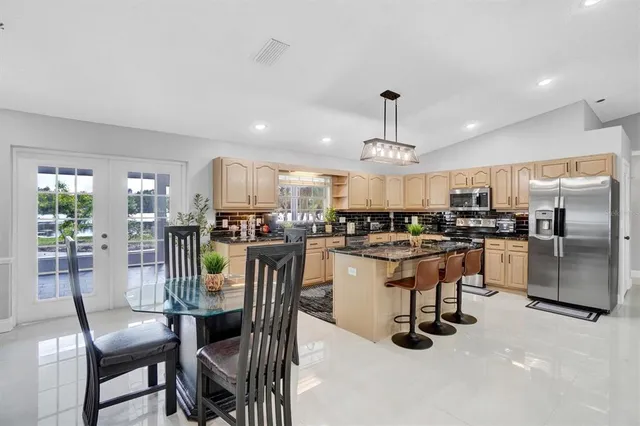 a kitchen with a refrigerator a dining table and chairs