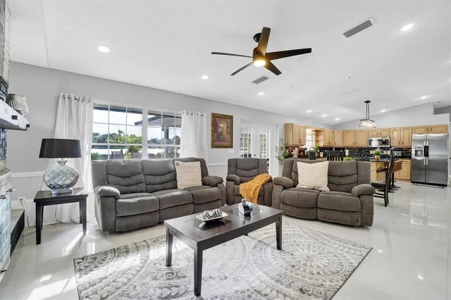 a living room with furniture kitchen view and a chandelier