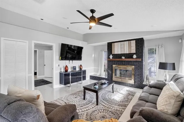 a living room with furniture a flat screen tv and a fireplace