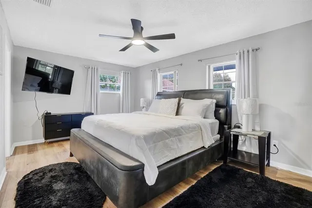 a spacious bedroom with a bed and a flat screen tv