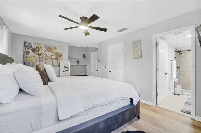 a bedroom with a large bed and a chandelier