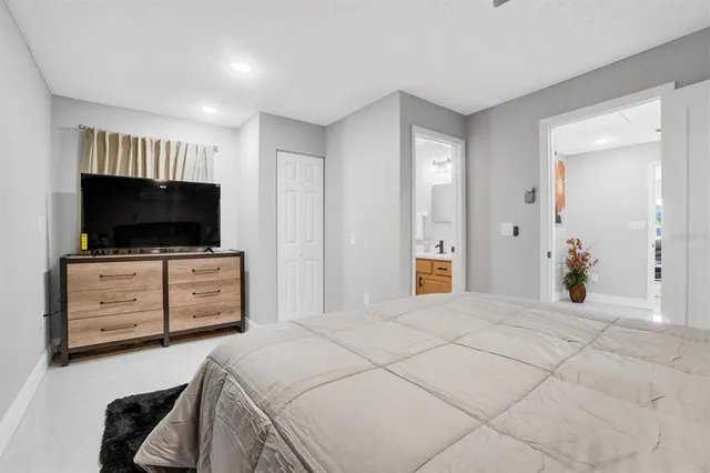 a bedroom with a bed and flat screen tv