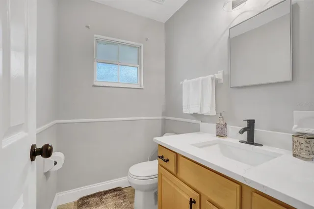 a bathroom with a sink vanity and toilet
