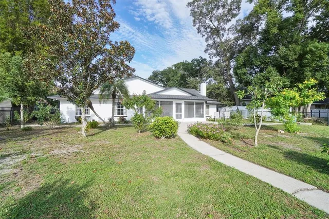 a view of house with backyard and trees