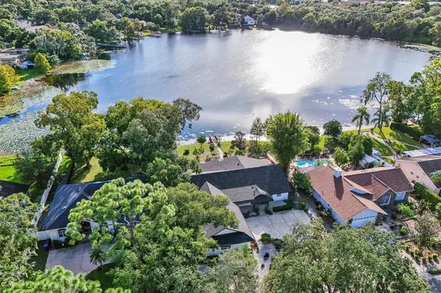 an aerial view of a house with a yard and lake view