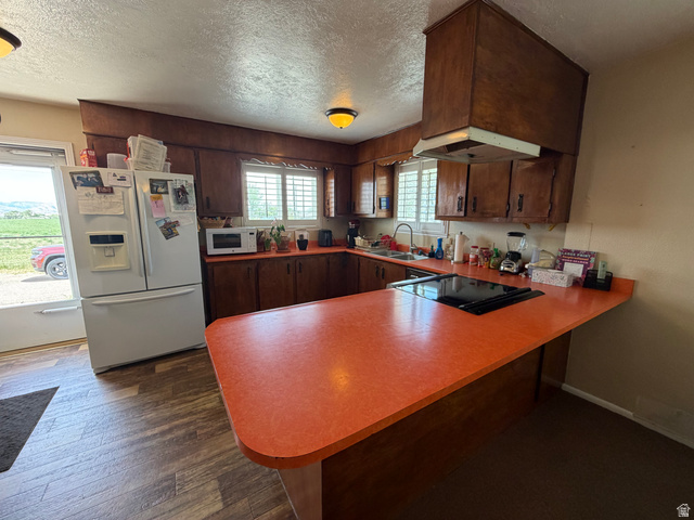 1043 East 4000th Street South Vernal, UT 84078 - Photo 13 of 31 Kitchen featuring an integrated cooktop on the peninsula, wood-finish flooring, and a white side-by-side refrigerator