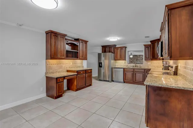 an empty room with a chandelier fan and windows