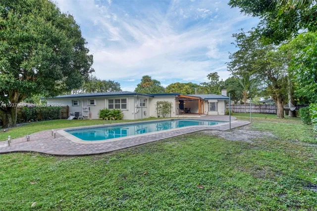 a view of a house with backyard and a tree