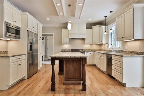 7 Davis Road Bedford, MA 01730 - Photo 9 of 30 a kitchen with white cabinets and stainless steel appliances