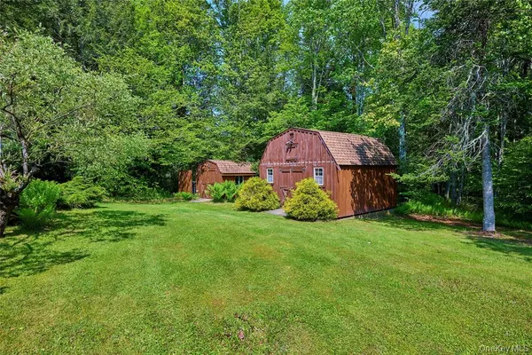 a front view of a house with a yard and trees