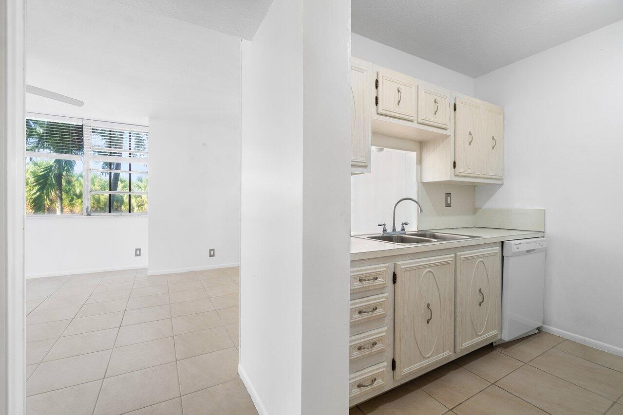 250 Northeast 20th Street, Unit 2250 Boca Raton, FL 33431 - Photo 6 of 22 a kitchen with granite countertop white cabinets and sink