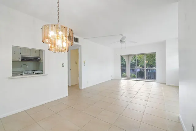 an empty room with an entryway and chandelier