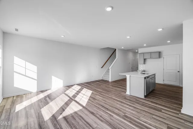 a kitchen with a sink and wooden floor