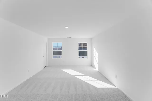 a view of a big room with windows and chandelier fan