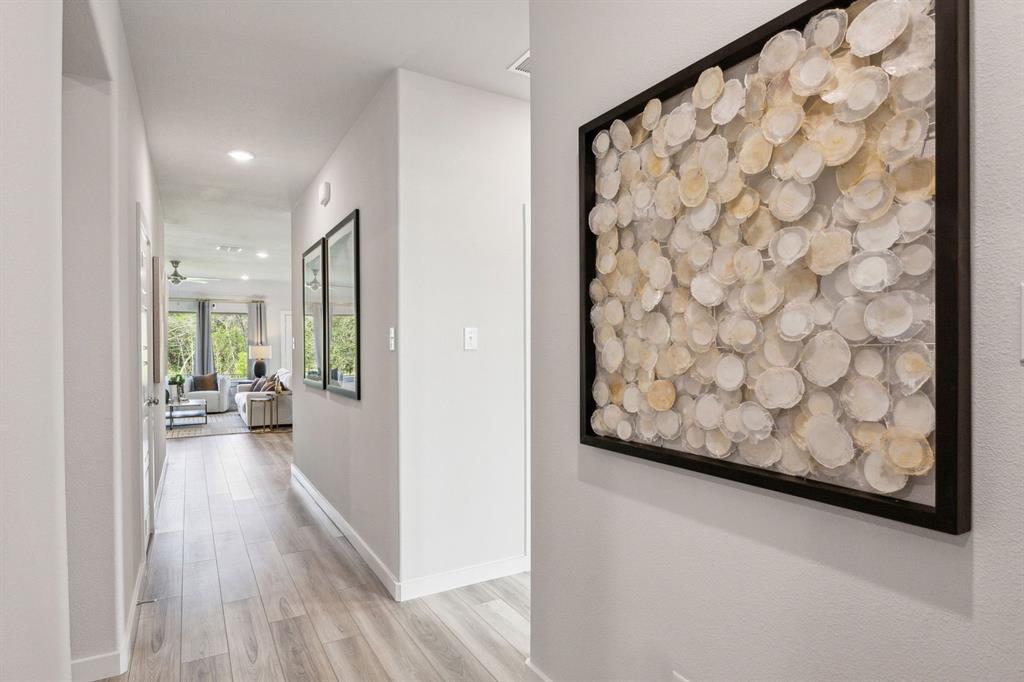 1932 Callington Way Forney, TX 75126 - Photo 23 of 25 a view of a hallway with wooden floor and a living room filled with furniture