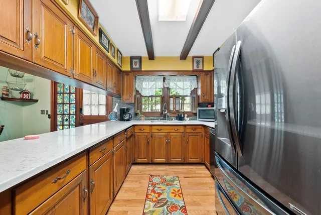 a large kitchen with stainless steel appliances granite countertop a refrigerator and a sink