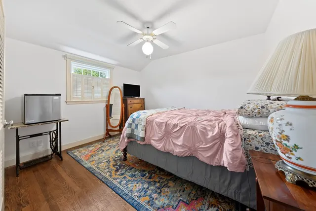 a bedroom with a bed a window and dresser