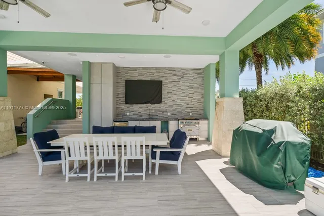 a living room with stainless steel appliances wooden floor and a fireplace
