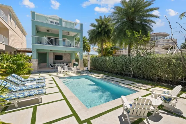a dining room with wooden floor a chandelier a glass table and chairs
