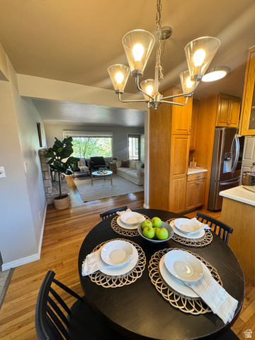 4245 3320 East Holladay, UT 84124 - Photo 24 of 51 Dining area featuring a dark-finish dining table and a contemporary chandelier