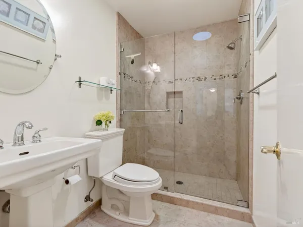 a bathroom with a sink toilet a mirror and shower