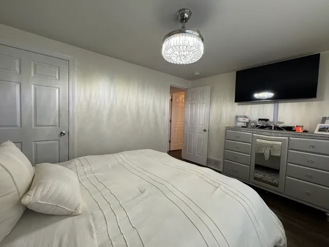 a bedroom with a bed and a chandelier