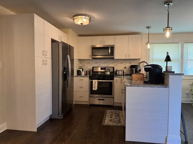 a kitchen with stainless steel appliances a refrigerator sink and microwave