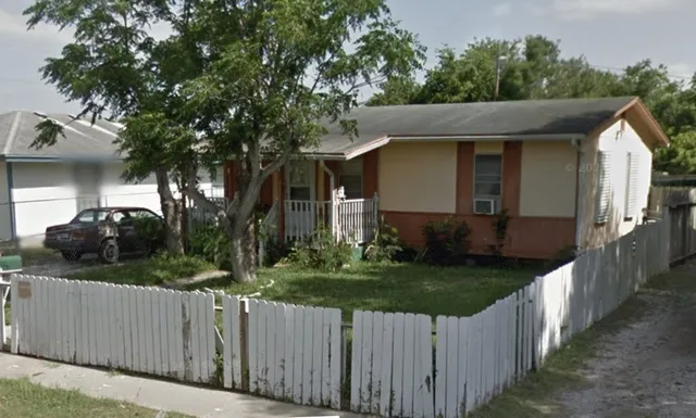 a front view of a house with yard and green space