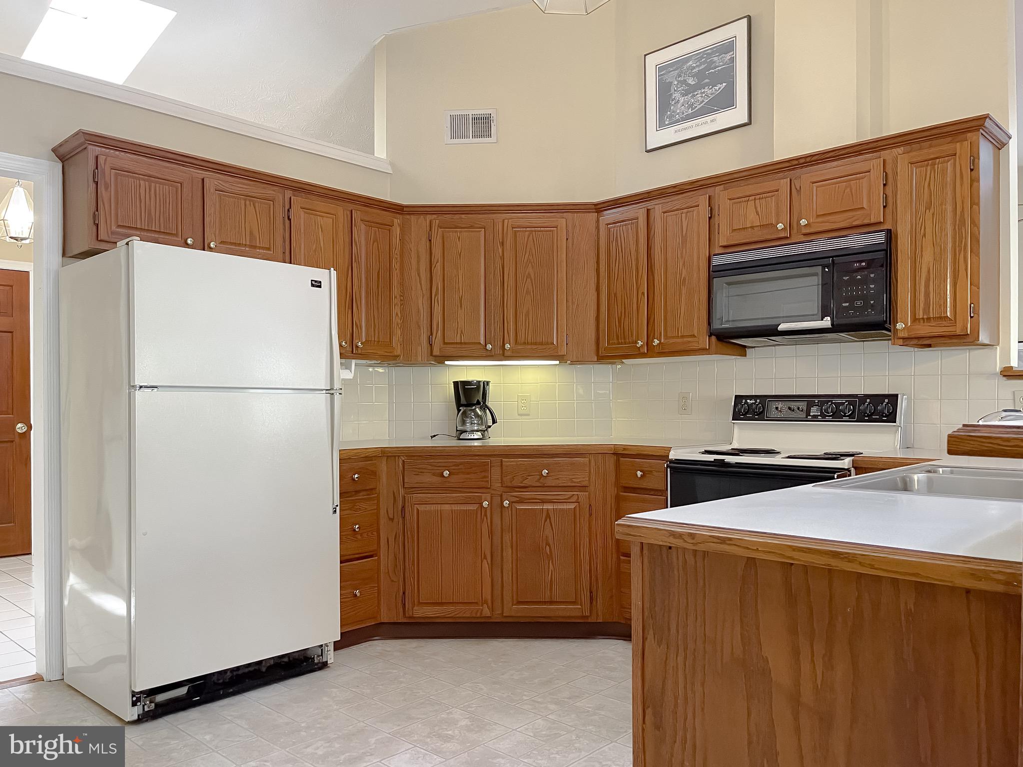 288 Elkins Lane Lusby, MD 20657 - Photo 34 of 73 a kitchen with stainless steel appliances a refrigerator a stove a microwave and sink