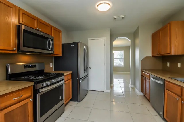 a kitchen with stainless steel appliances granite countertop a stove a refrigerator and a microwave