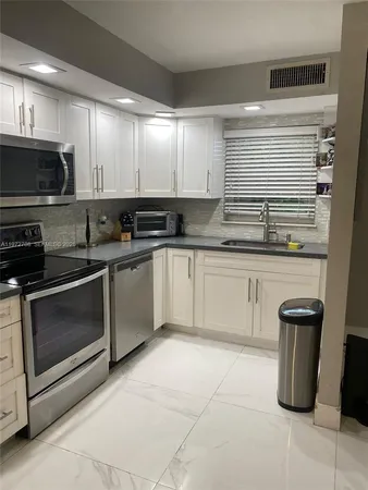 a kitchen with a sink stove and cabinets