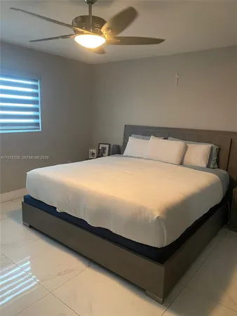 a large bed sitting in a bedroom next to a window