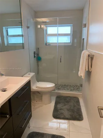 a bathroom with a sink a toilet a shower and a mirror