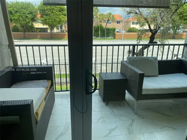 a balcony with furniture and a potted plant