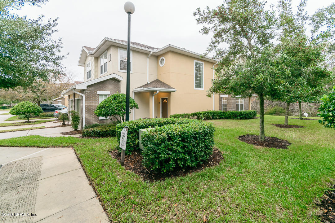 5663 Greenland Road, Unit 1008 Jacksonville, FL 32258 - Photo 2 of 24 a view of a white house next to a yard with big trees