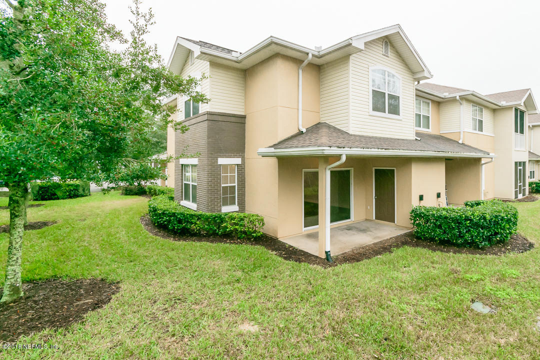 5663 Greenland Road, Unit 1008 Jacksonville, FL 32258 - Photo 22 of 24 a view of a white house with a small yard and large tree