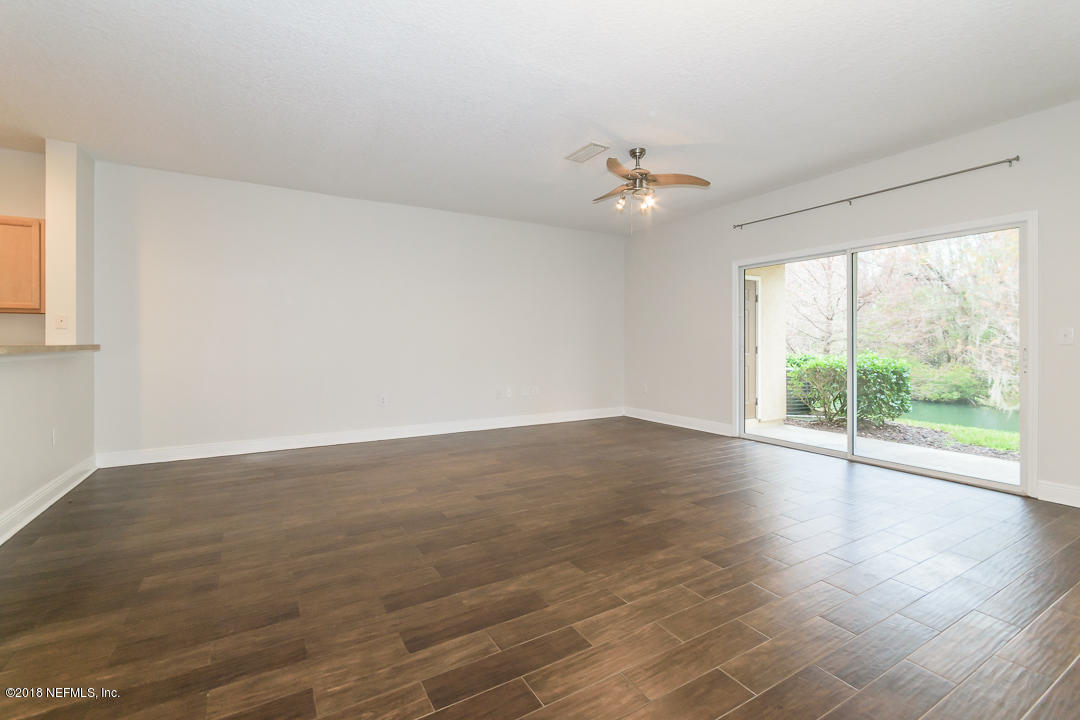 5663 Greenland Road, Unit 1008 Jacksonville, FL 32258 - Photo 5 of 24 an empty room with wooden floor fan and windows