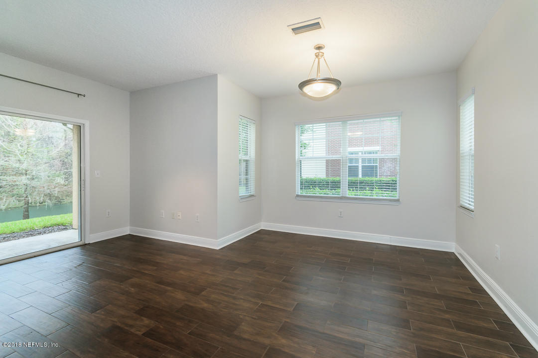 5663 Greenland Road, Unit 1008 Jacksonville, FL 32258 - Photo 6 of 24 an empty room with wooden floor chandelier and windows