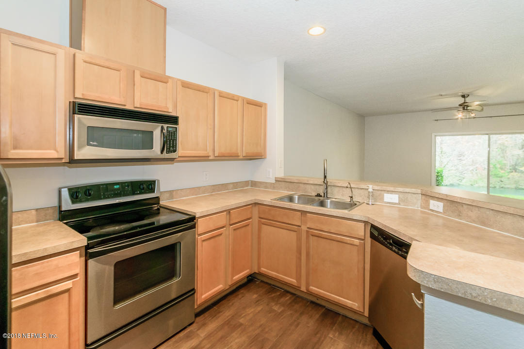 5663 Greenland Road, Unit 1008 Jacksonville, FL 32258 - Photo 9 of 24 a kitchen with a sink stove and microwave
