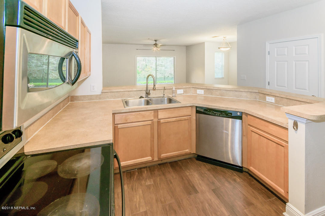 5663 Greenland Road, Unit 1008 Jacksonville, FL 32258 - Photo 10 of 24 a kitchen with a sink stove and cabinets