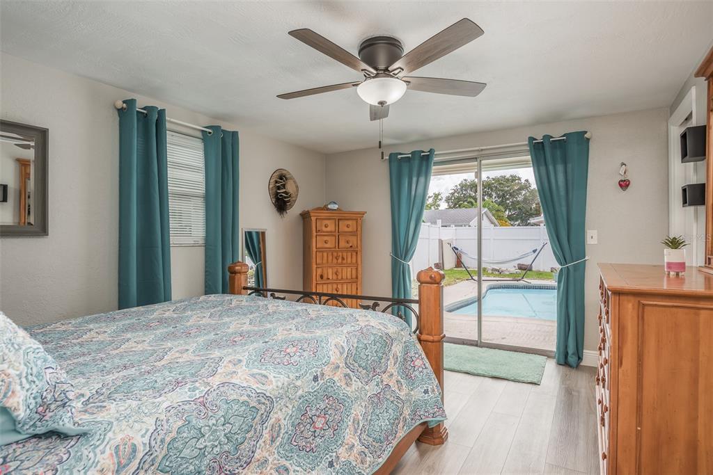 8906 Catalina Drive Port Richey, FL 34668 - Photo 13 of 34 a bedroom with a large bed and a chandelier
