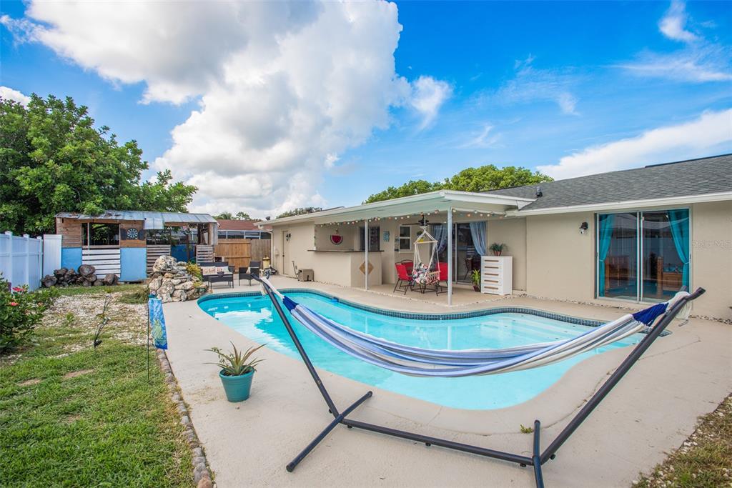 8906 Catalina Drive Port Richey, FL 34668 - Photo 31 of 34 a front view of a house with swimming pool and furniture