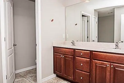 a bathroom with a double vanity sink and large mirror