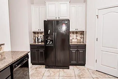 a kitchen with stainless steel appliances granite countertop a refrigerator and a sink