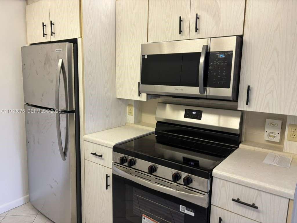 2052 Exeter C, Unit 2052 Boca Raton, FL 33434 - Photo 2 of 35 a kitchen with stainless steel appliances a refrigerator stove and microwave
