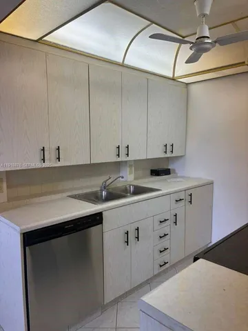 a kitchen with a sink dishwasher and cabinets